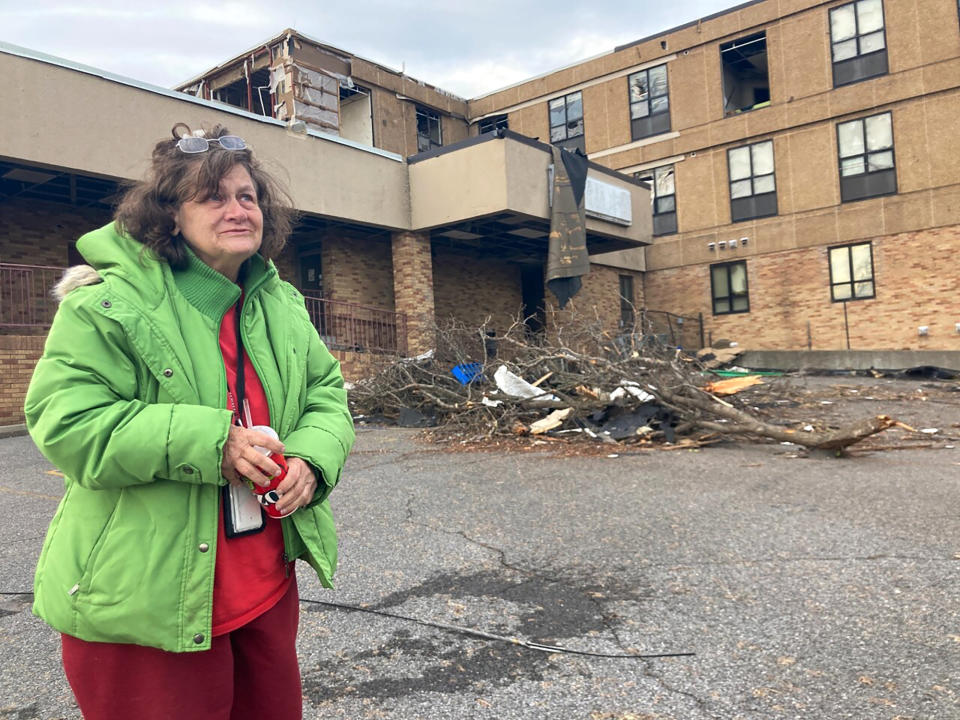 Judy Burton stands outside her apartment building, which was severely damaged in Friday's tornados, in Mayfield, Ky., Sunday, Dec. 12, 2021. Burton and her dog barely escaped as one of the most devastating tornados in American history tore apart her town of 10,000 people.(AP Photo/Claire Galofaro)