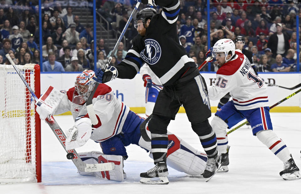 Montreal Canadiens goaltender Cayden Primeau (30) makes a save against Tampa Bay Lightning defenseman Nick Perbix (48) during the third period of an NHL hockey game Saturday, March 2, 2024, in Tampa, Fla. (AP Photo/Jason Behnken)