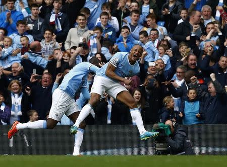 Manchester City's captain Vincent Kompany (R) celebrates after scoring against West Ham United during their English Premier League soccer match at the Etihad Stadium in Manchester, northern England May 11, 2014. REUTERS/Darren Staples