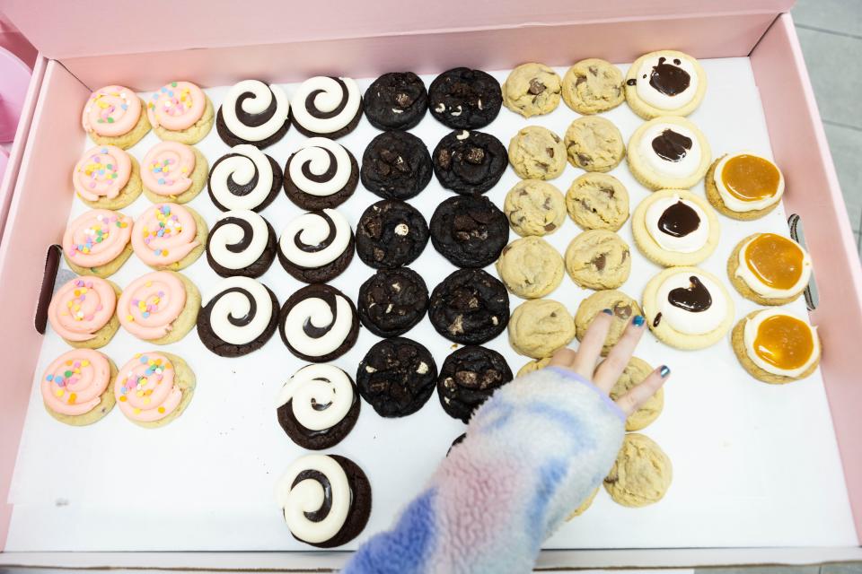 Melanie Tuneberg, 10, picks out cookies to take home during a press preview of the new Crumbl Cookies on Nov. 8, 2023.