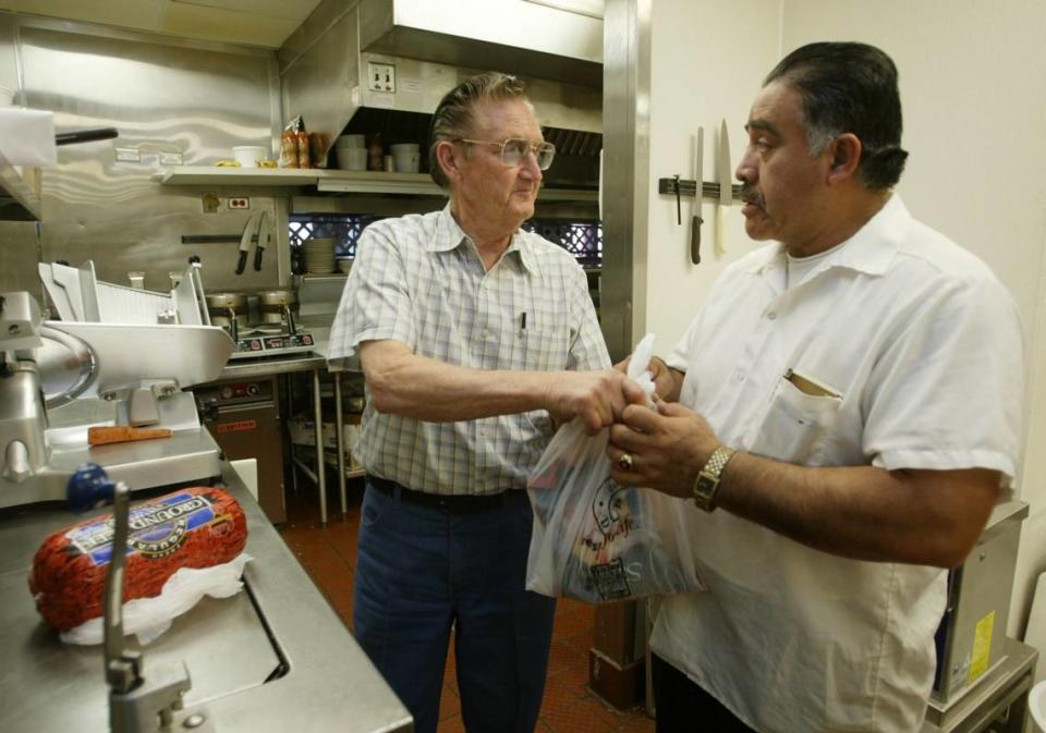 H.T. “Chic” Brooks, left, talks with kitchen manager Alex Dias while dropping off ingredients for the St. Patrick Day special at the Country Waffles restaurant in Hanford in this Fresno Bee file photo from 2005.