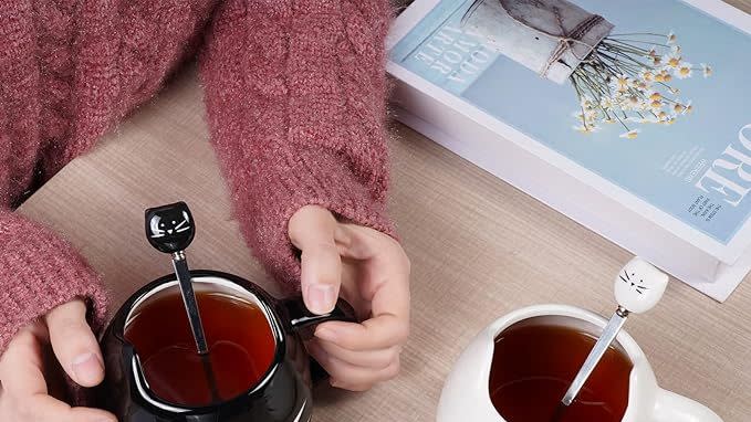 a person holding a spoon and a cup of tea