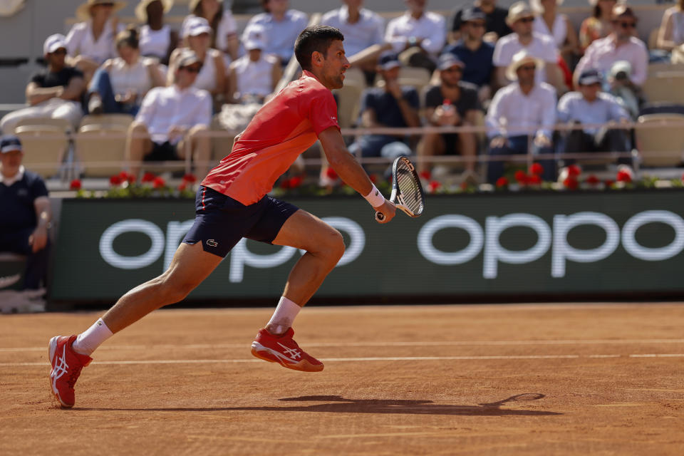 Serbia's Novak Djokovic runs to the net to play a shot against Russia's Karen Khachanov during their quarterfinal match of the French Open tennis tournament at the Roland Garros stadium in Paris, Tuesday, June 6, 2023. (AP Photo/Jean-Francois Badias)