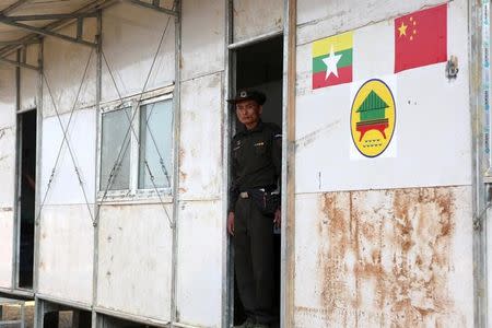 A Myanmar immigration official stands at the door of a building inside the camp set up by Myanmar's Social Welfare, Relief and Resettlement Minister to prepare for the repatriation of displaced Rohingyas, who fled to Bangladesh, outside Maungdaw in the state of Rakhine, Myanmar January 24, 2018. REUTERS/Stringer