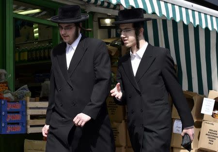 Orthodox Jewish men walk past a row of shops in Stamford Hill north London, Britain May 3, 2016. REUTERS/Hannah McKay