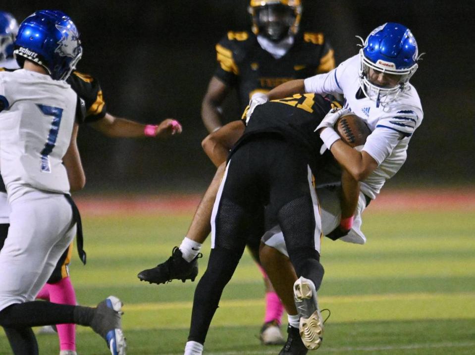 Edison’s James Rose, foreground, stops Madera’s Jr Galindo on a run Friday, Oct. 20, 2023 in Fresno.