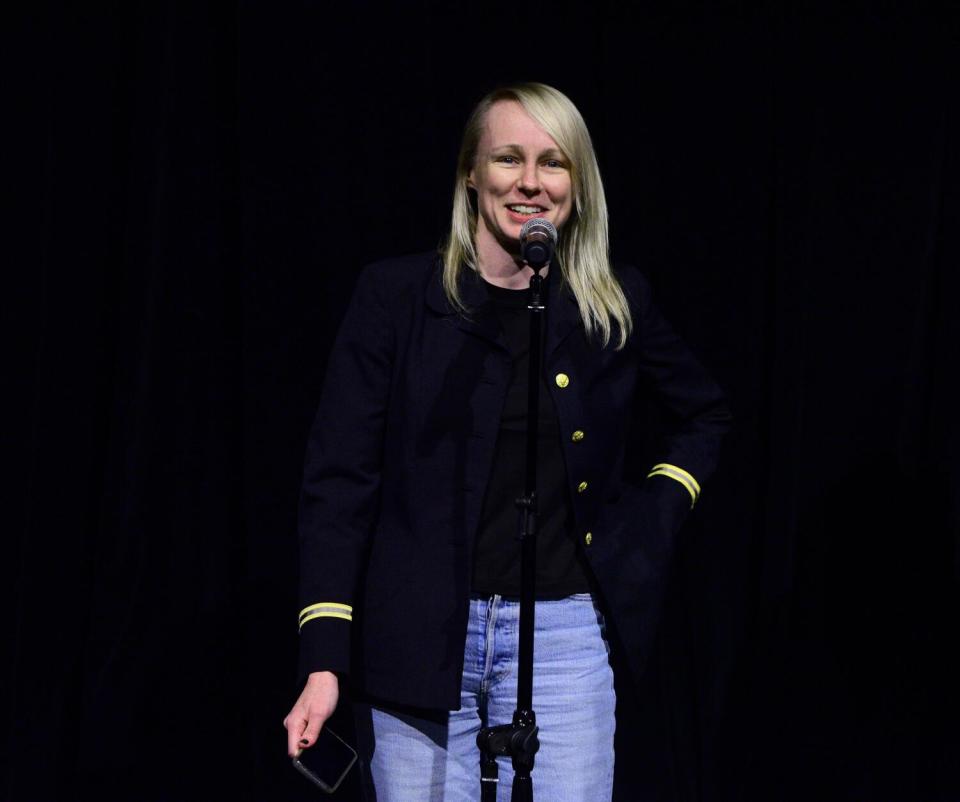 A woman introduces a screening.