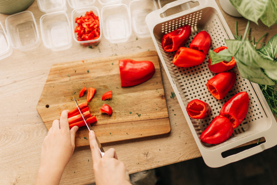 African American woman's hand cutting a tomato