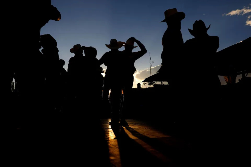 Los vaqueros bailan al caer la noche.