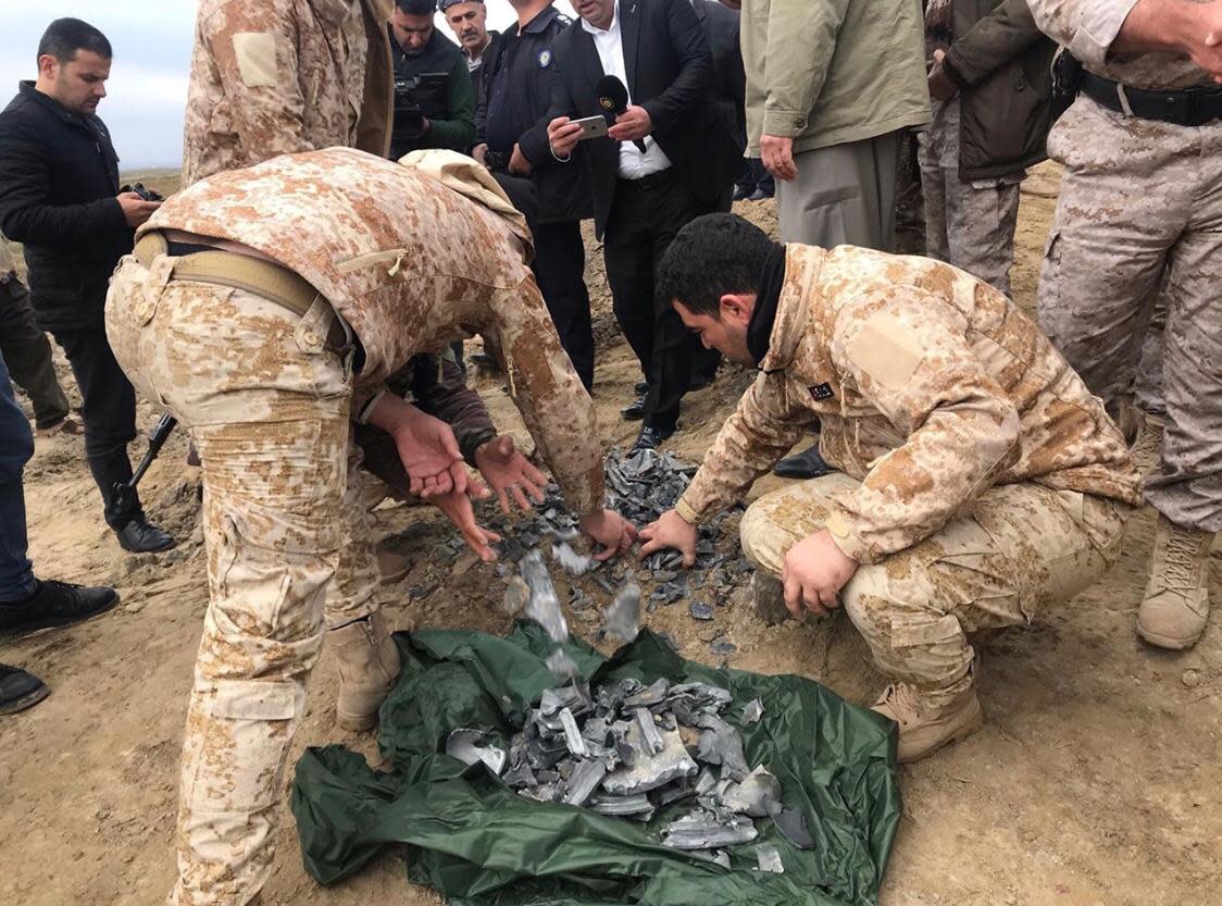 Kurdische Sicherheitskräfte sammeln am Einschlagsort einer iranischen Rakete bei Erbil Splitter ein (Bild: Tobias Huch/Aram)