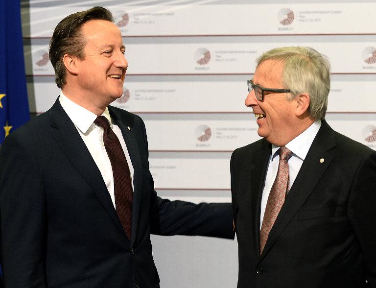 British Prime Minister David Cameron (left) is welcomed by European Commission President Jean-Claude Juncker in Riga on May 22, 2015