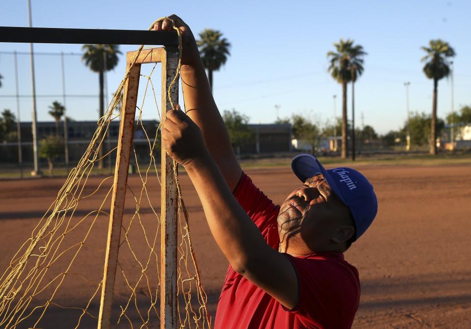 Antonio Velasquez, a pastor and director of the Maya Chapin soccer league of over 108 teams, prepares a goal net prior to the night games Wednesday, April 17, 2019, in Phoenix. (AP Photo/Ross D. Franklin)