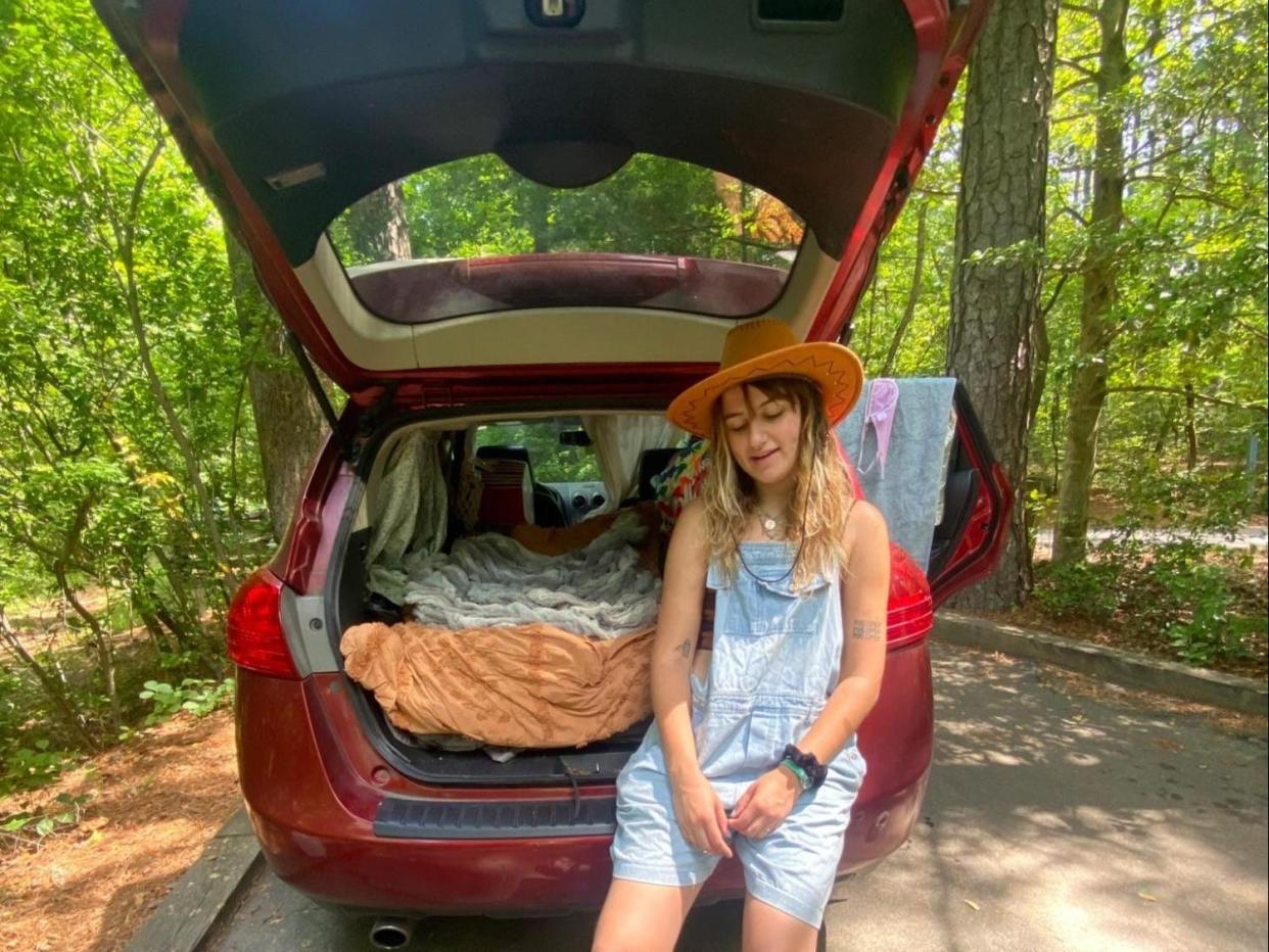 Kylie Vincent sitting in the trunk of her SUV with her dog in a wheelchair