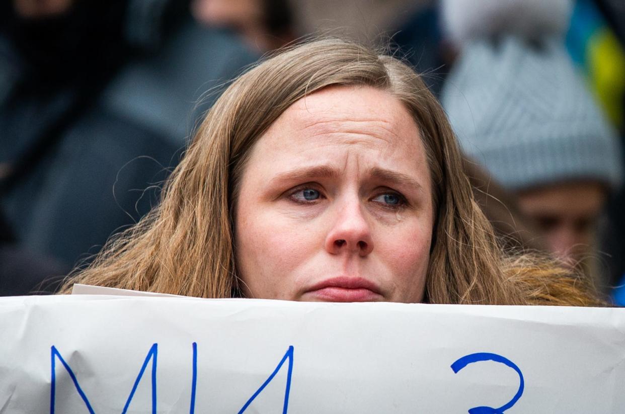 Maggie Stewart sheds a tear as the crowd in Austin sings a Ukrainian song Thursday while protesting Russia's invasion of Ukraine. More than 100 people rallied, chanting and singing songs outside the Capitol.