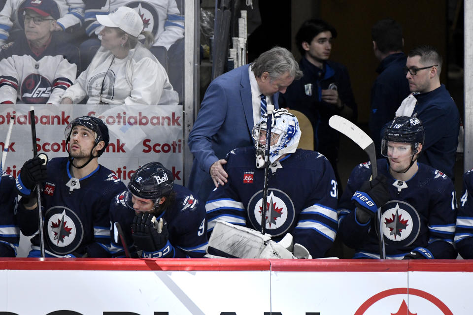 Winnipeg Jets coach Rick Bowness speaks with goaltender Connor Hellebuyck (37) after he was pulled for the extra attacker against the Colorado Avalanche during the third period in Game 2 of an NHL hockey Stanley Cup first-round playoff series Tuesday, April 23, 2024, in Winnipeg, Manitoba. (Fred Greenslade/The Canadian Press via AP)