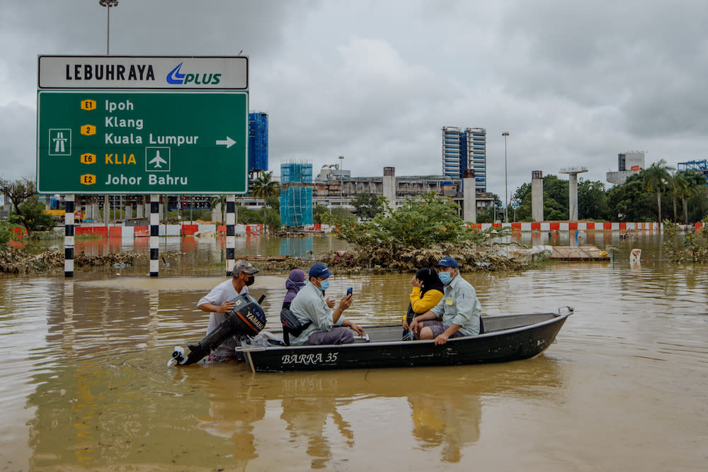 A man uses a boat to rescue people after persistent rainfall caused massive floods in Shah Alam, December 19, 2021. ― Picture by Shafwan Zaidon