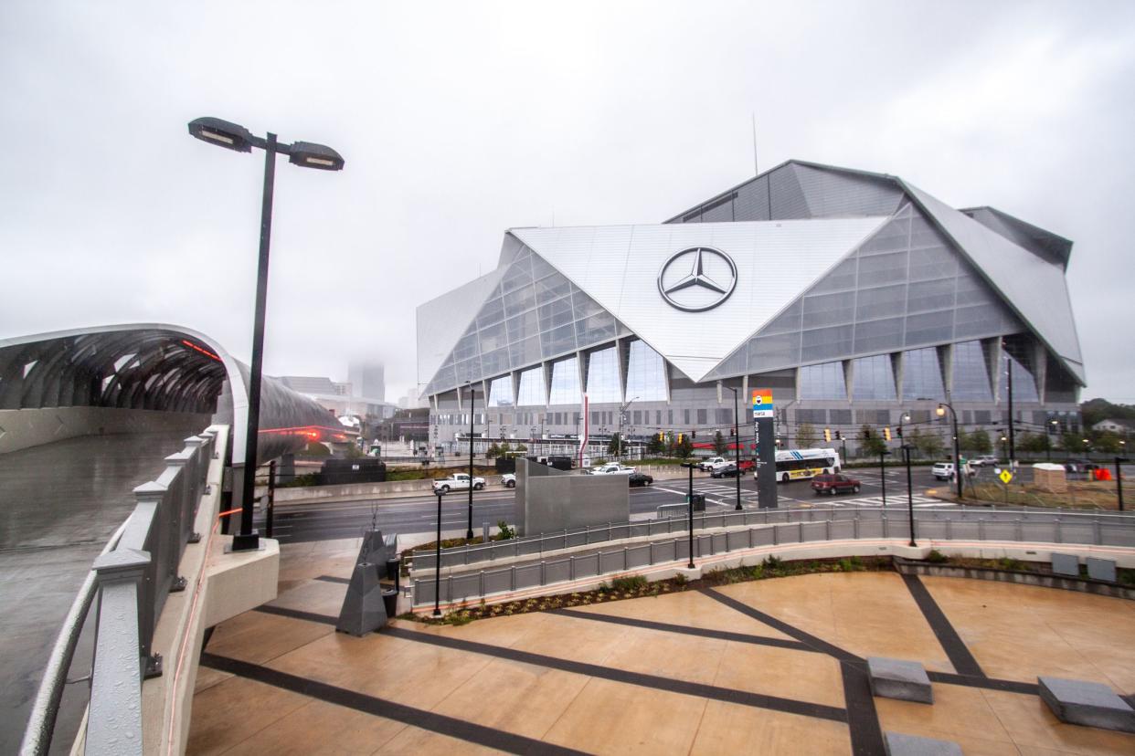 Atlanta Falcons, Mercedes-Benz Stadium, Atlanta, exterior of front with parking and walkway on a somewhat rainy day