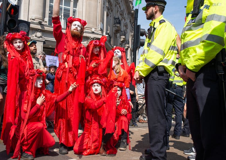 <span class="caption">Performance troupe Red Brigade parade at the Extinction Rebellion demonstration in London, 2019.</span> <span class="attribution"><a class="link " href="https://www.shutterstock.com/image-photo/london-uk-19th-april-2019-performance-1388120078" rel="nofollow noopener" target="_blank" data-ylk="slk:Shutterstock;elm:context_link;itc:0;sec:content-canvas">Shutterstock</a></span>