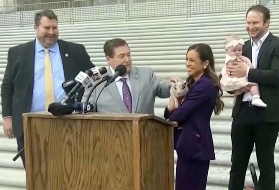 In this image, taken from video, Louisiana state Rep. Lauren Ventrella, who adopted the piglet named Earl "Piglet" Long, smiles alongside Lt. Gov. Billy Nungesser, Wednesday, Feb. 28, 2024, in Baton Rouge, Louisiana.