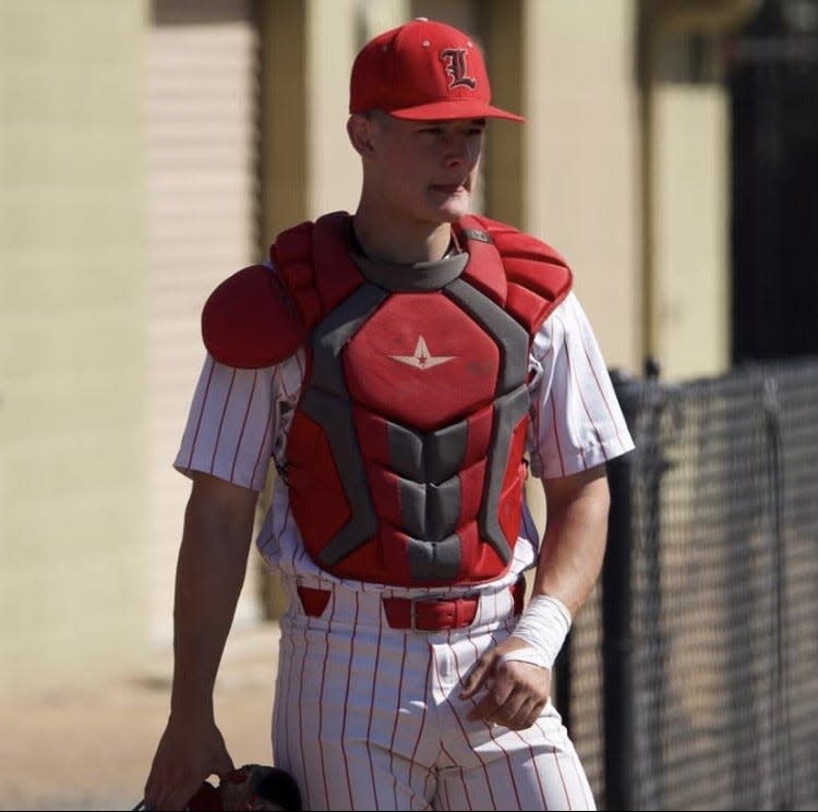 Caleb Hendricks of Lincoln baseball plays as a catcher during one of the Trojans game in the 2022-23 season.