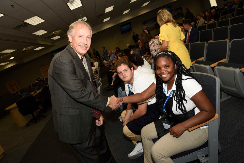 St. Lucie County Administrator Howard Tipton, left, shakes the hand of Student Perks student Jerqueria Fitzgerald.