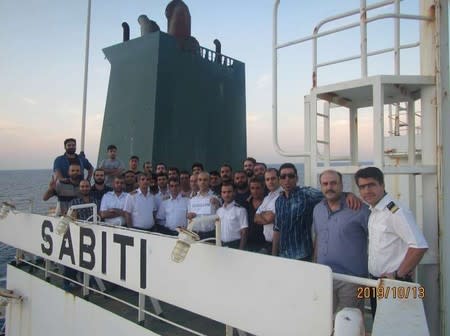 The crew of the Iranian-owned Sabiti oil tanker pose for a photo as they sail in the Red Sea