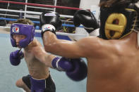 Japanese boxer and the WBA and IBF bantamweight world champion Naoya Inoue, left, trains at the Ohashi Boxing Gym in Yokohama, near Tokyo on Nov. 23, 2021. Drawing praise as one of the best "pound for pound" active boxers around, and the best out of Asia since the legendary Manny Pacquiao, Inoue now has his eyes on the big money and American stardom. (AP Photo/Koji Sasahara)