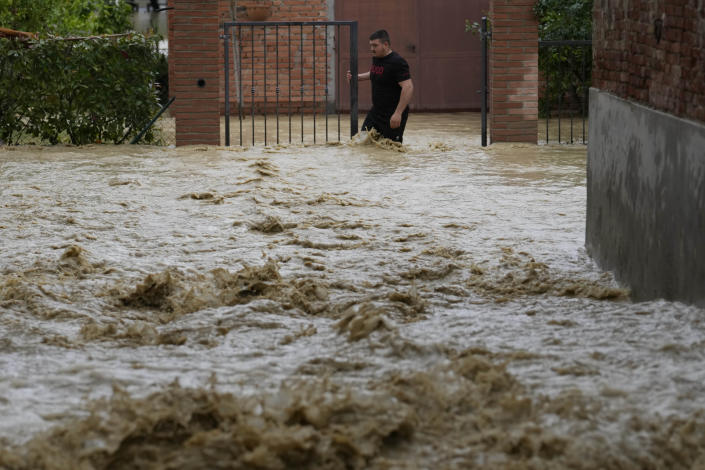 FILE - A man walks in a flooded street in the village of Castel Bolognese, Italy, May 17, 2023. The floods that sent rivers of mud tearing through towns in Italy’s northeast are another soggy dose of climate change's all-or-nothing weather extremes, something that has been happening around the globe, scientists say. (AP Photo/Luca Bruno, File)