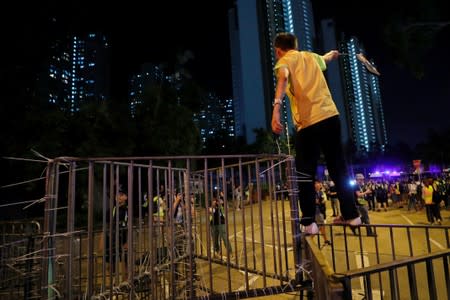 Protester stands on the barriers after a march at Sheung Shui, Hong Kong