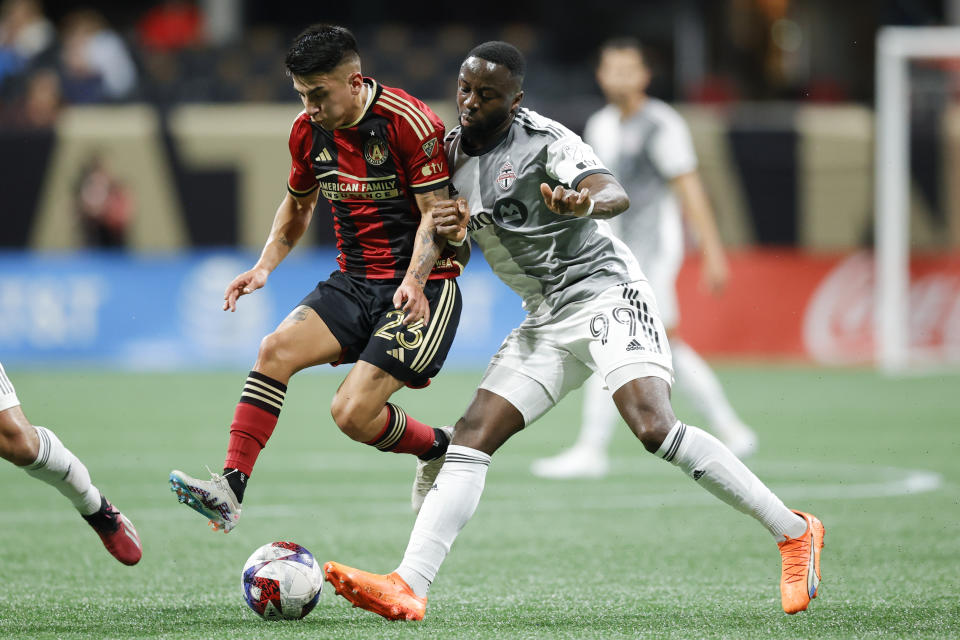 Atlanta United midfielder Thiago Almada, left, and Toronto FC forward Adama Diomandé, right, battle for the ball during the first half of an MLS soccer match, Saturday, March 4, 2023, in Atlanta. (AP Photo/Alex Slitz)