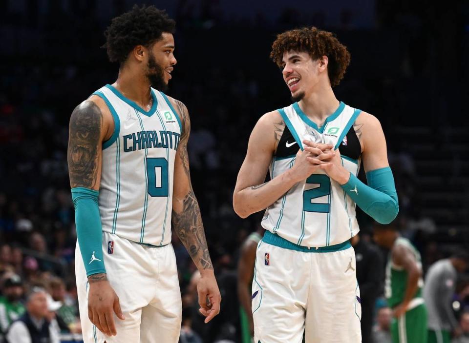 Charlotte Hornets forward forward Miles Bridges, left and guard LaMelo Ball, right, talk during a timeout against the Boston Celtics at Spectrum Center in Charlotte in March 2022.