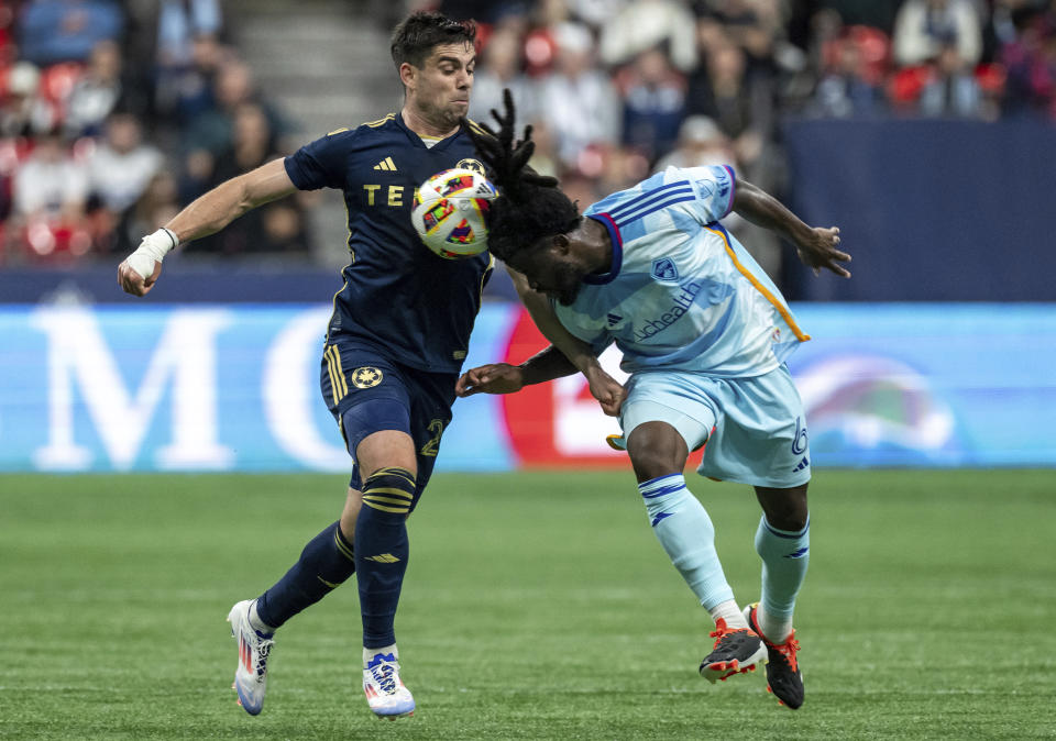 Vancouver Whitecaps' Brian White, left, and Colorado Rapids' Lalas Abubakar, right, vie for the ball during the second half of an MLS soccer match Saturday, June 1, 2024, in Vancouver, British Columbia. (Ethan Cairns/The Canadian Press via AP)