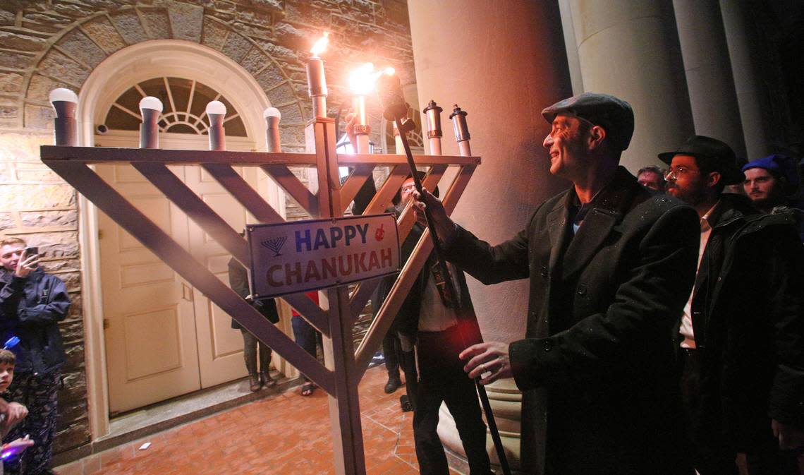 Ezra Nanes, State College’s first Jewish mayor, lights a 6 foot tall public Jewish Hanukkah menorah Sunday on the fourth night of the eight-day Festival of Lights, hosted by Chabad of Penn State, at Old Main.