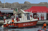 Italian firefighter divers bring ashore in a green bag the body of one of the victims of the UK flag vessel Bayesian, Wednesday, Aug. 21, 2024. The luxury sail yacht was hit by a violent sudden storm and sunk early Monday, while at anchor off the Sicilian village of Porticello near Palermo, in southern Italy. (AP Photo/Salvatore Cavalli)