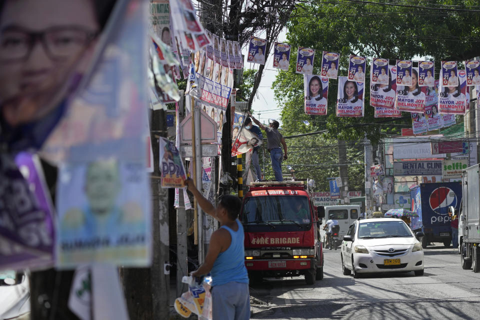 Village workers remove election campaign posters in Quezon city, Philippines on Wednesday, May 11, 2022. Marcos, the namesake son of longtime dictator Ferdinand Marcos, apparent landslide victory in the Philippine presidential election is raising immediate concerns about a further erosion of democracy in Asia and could complicate American efforts to blunt growing Chinese influence and power in the Pacific. (AP Photo/Aaron Favila)