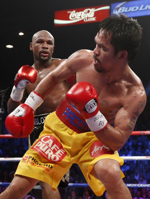 Floyd Mayweather Jr., (at back) and Manny Pacquiao spar during their welterweight unification bout