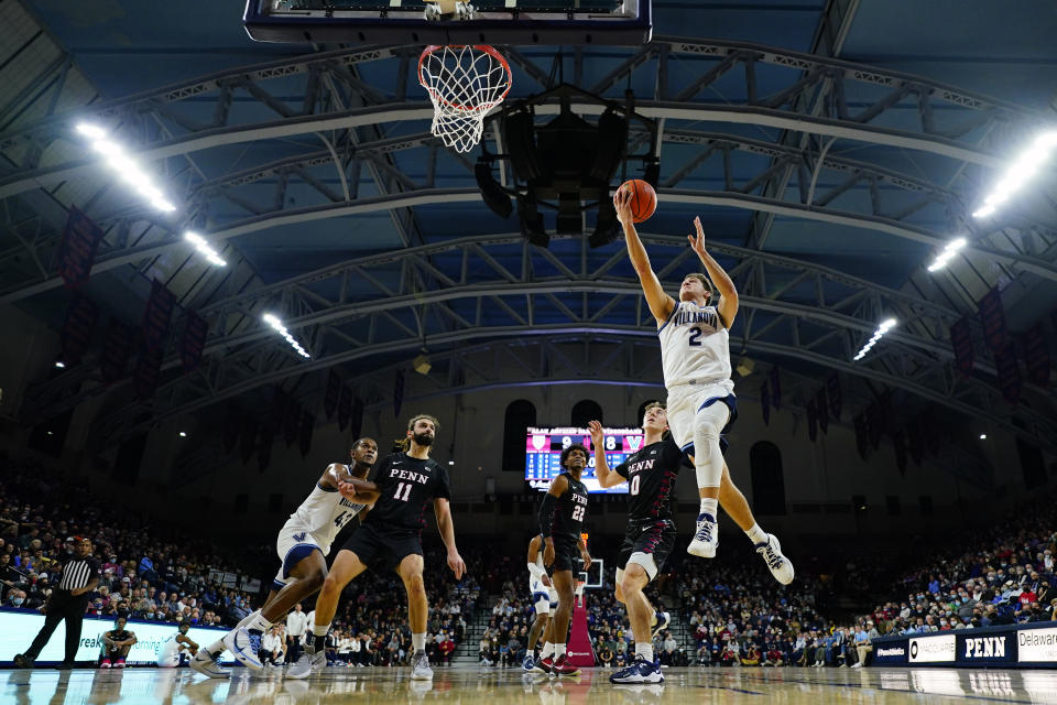 Villanova's Collin Gillespie (2) goes up for a shot past Pennsylvania's Clark Slajchert (0) during the first half of an NCAA college basketball game, Wednesday, Dec. 1, 2021, in Philadelphia. (AP Photo/Matt Slocum)