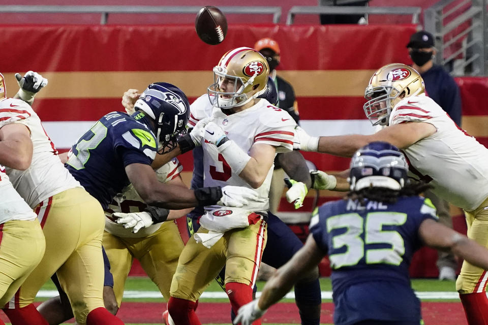 Seattle Seahawks defensive end Carlos Dunlap forces San Francisco 49ers quarterback C.J. Beathard (3) to fumble during the second half of an NFL football game, Sunday, Jan. 3, 2021, in Glendale, Ariz. (AP Photo/Rick Scuteri)