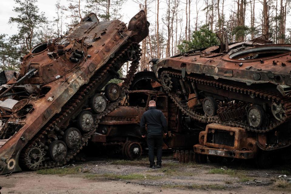 A police officer looks at destroyed Russian armored vehicles at a collection point in an animal feed plant in the recently retaken town of Lyman in Donetsk region, on October 5, 2022, amid the Russian invasion of Ukraine. (Photo by Yasuyoshi CHIBA / AFP) (Photo by YASUYOSHI CHIBA/AFP via Getty Images) ORIG FILE ID: AFP_32KT2GX.jpg