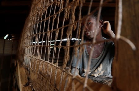 A young informal gold miner glances out from inside a makeshift gold processing room at the site of Nsuaem-Top