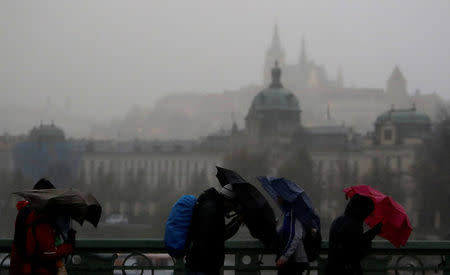 FILE PHOTO: People hold umbrellas in heavy rain and strong wind in Prague, Czech Republic October 29, 2017. REUTERS/David W Cerny