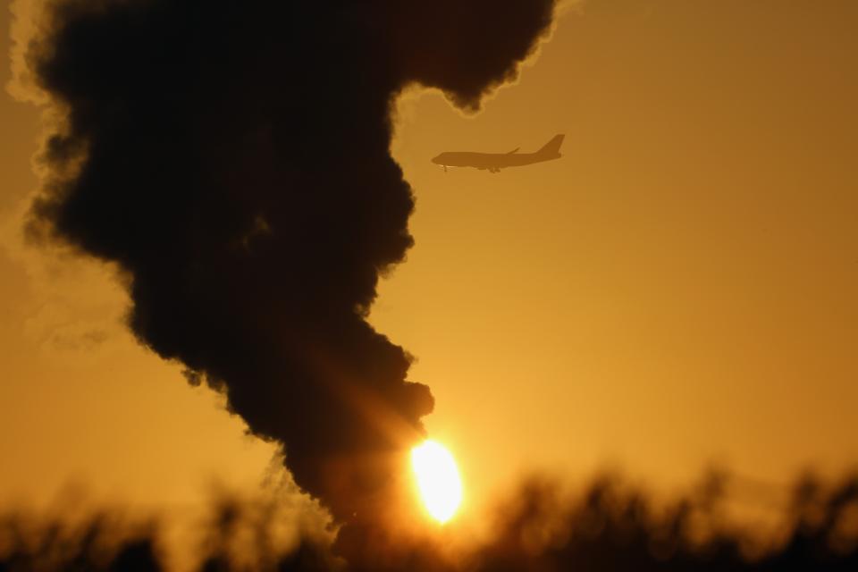 KNUTSFORD, ENGLAND - DECEMBER 11: An aircaft makes its approach to Manchester Airport as cold weather accentuates the steam from a grass dryer in the Cheshire countryside on December 11, 2012 in Knutsford, England. Forecasters are warning that the UK could experience the coldest day of the year so far tomorrow, as temperatures could drop as low as -14C, bringing widespread ice, harsh frosts and freezing fog. Travel disruption is expected with warnings for heavy snow. (Photo by Christopher Furlong/Getty Images)