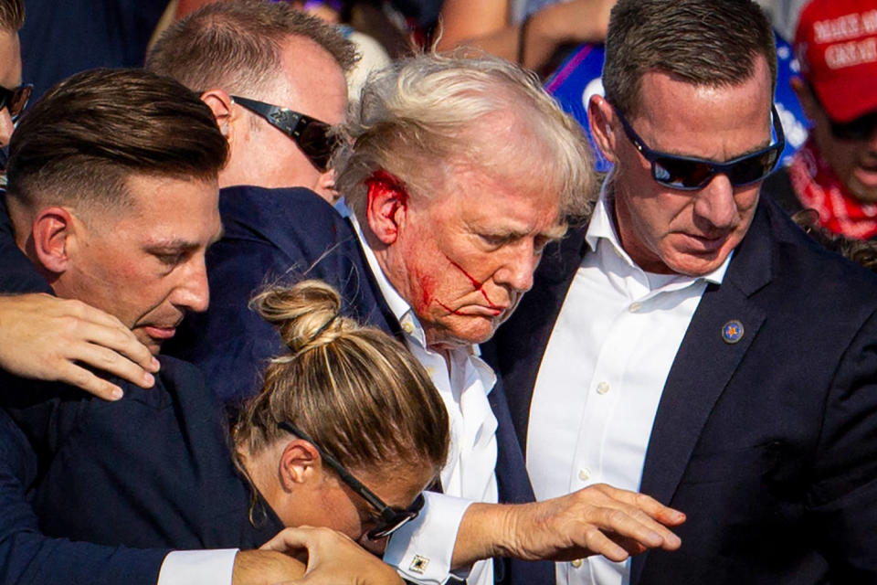 Donald Trump is seen with blood on his face surrounded by secret service agents. (Rebecca Droke / AFP via Getty Images)