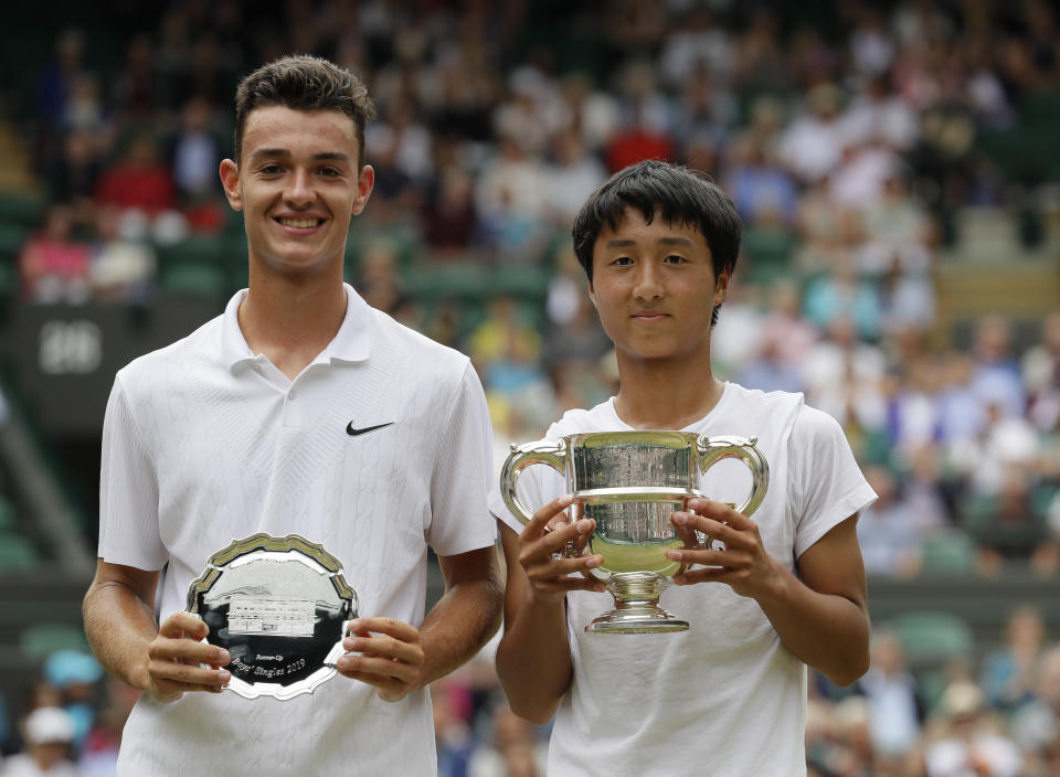 Japan's Shintaro Mochizuki and Spain's Carlos Gimeno Valero pose with the trophies after the boys' singles final match of the Wimbledon Tennis Championships in London, Sunday, July 14, 2019. (AP Photo/Kirsty Wigglesworth)