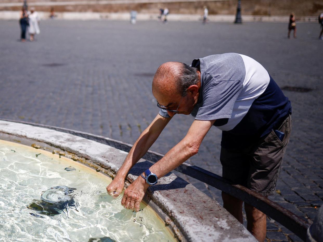A man cools off at a fountain in rome (REUTERS)