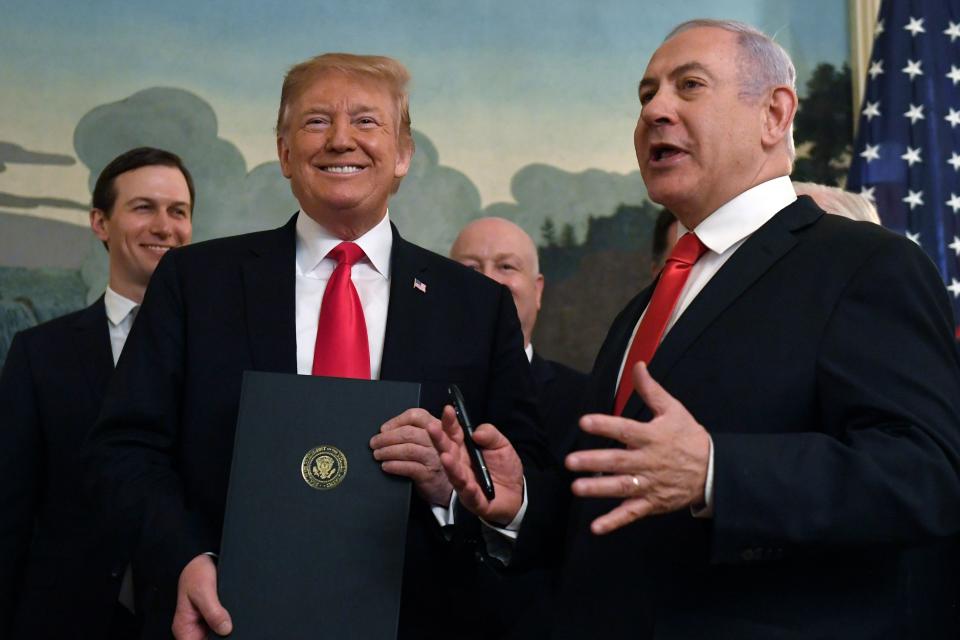 President Donald Trump smiles as he holds a proclamation as Israeli Prime Minister Benjamin Netanyahu, right, speaks in the Diplomatic Reception Room at the White House in Washington, Monday, March 25, 2019. Trump signed an official proclamation formally recognizing Israel's sovereignty over the Golan Heights.
