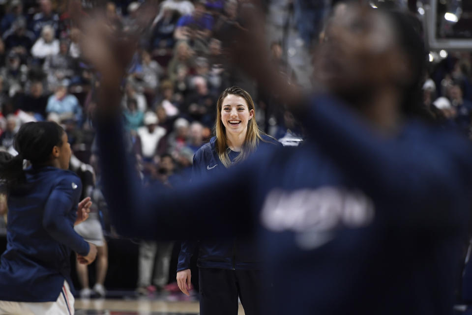 Connecticut's Katie Lou Samuelson watches her teammates warm up before an NCAA college basketball game in the American Athletic Conference tournament quarterfinals against East Carolina, Saturday, March 9, 2019, at Mohegan Sun Arena in Uncasville, Conn. Samuelson is sitting out the tournament with an injury. (AP Photo/Jessica Hill)