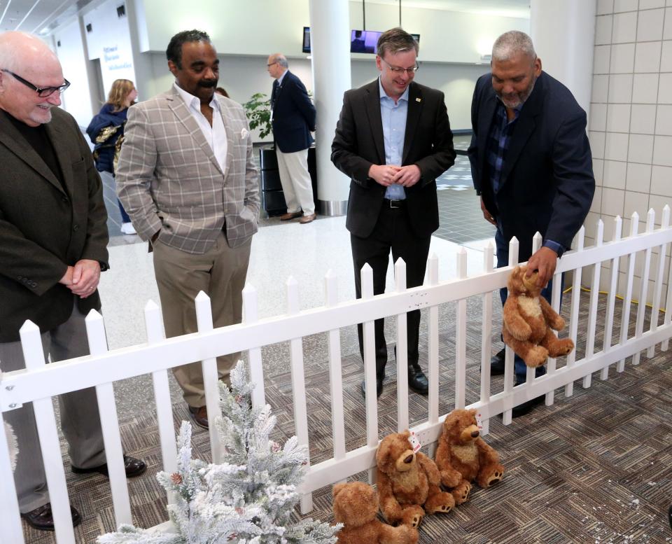 Frederick Pryor, a resident at the Robert L. Miller Sr. Veterans Center, places a bear in the bear den at the Bears in the Air news conference Tuesday, Nov. 29, 2022, at the South Bend International Airport. Looking on is, from left, David Sage, vice president of the St. Joseph County Airport Authority Board; Rafael Morton, president of the St. Joseph County Council; and South Bend Mayor James Mueller.