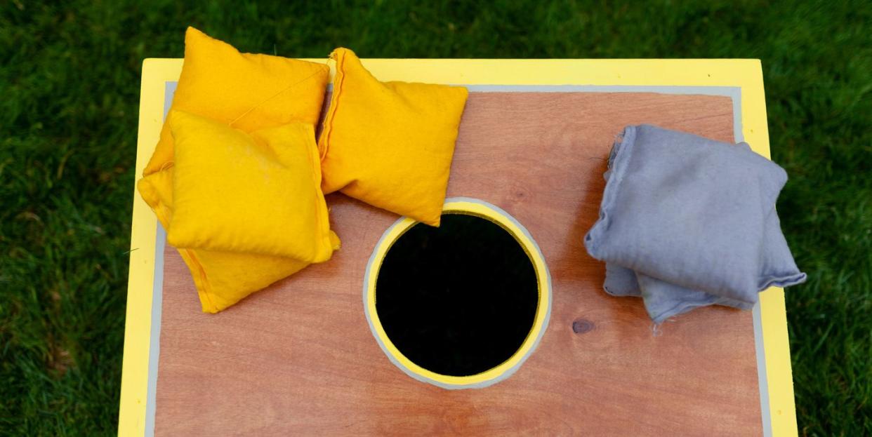 above view of a cornhole game with yellow and gray beanbags