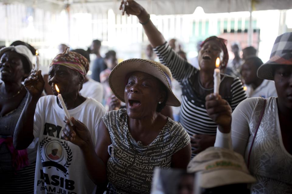 In this Dec. 13, 2018 photo, Miliana Louis cries during a memorial for the victims of a massacre in the La Saline slum of Port-au-Prince, Haiti. Louis said her 22-year-old son James was killed with a machete in the mass killing on Nov. 13, and his body fed to pigs. (AP Photo/Dieu Nalio Chery)